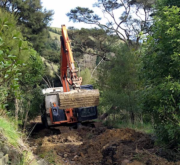 a digger and truck clearing the access road